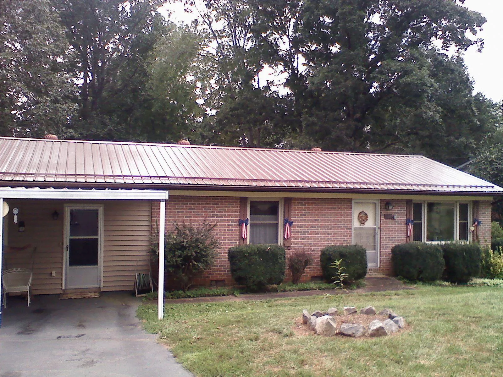 Bronze metal roof and carport on a brick ranch home — Roof Repair work by our crew in Central